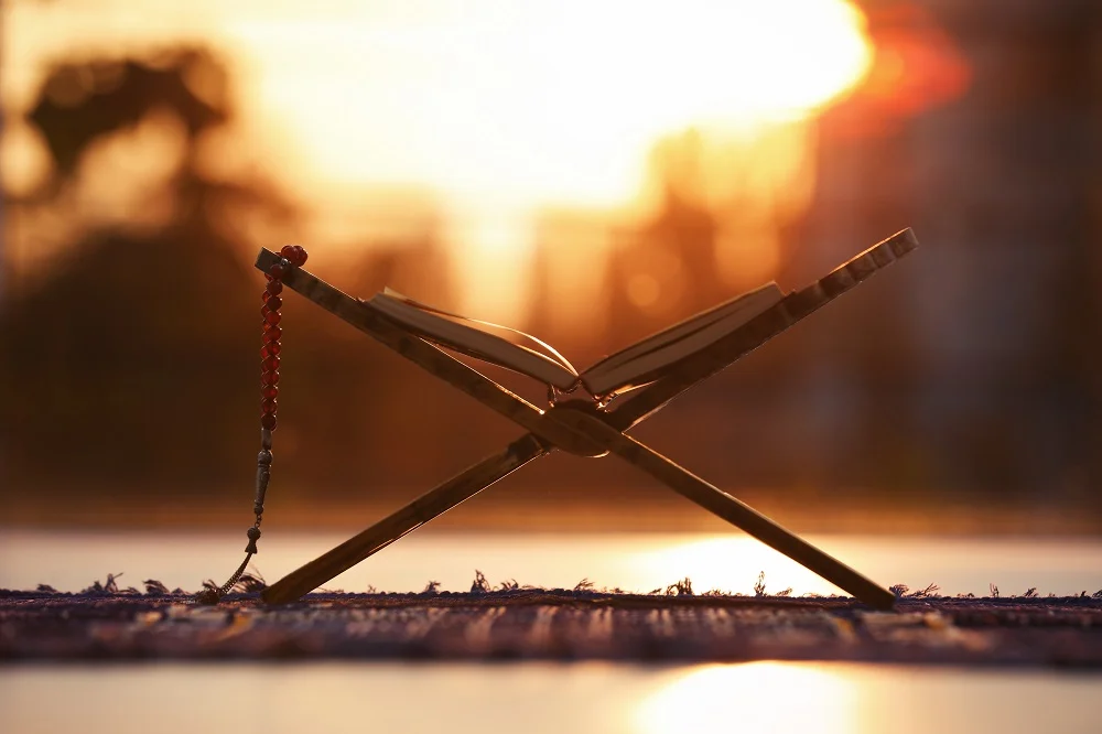 rehal with open quran and prayer beads on muslim p 2026 03 01 08 48 32 utc