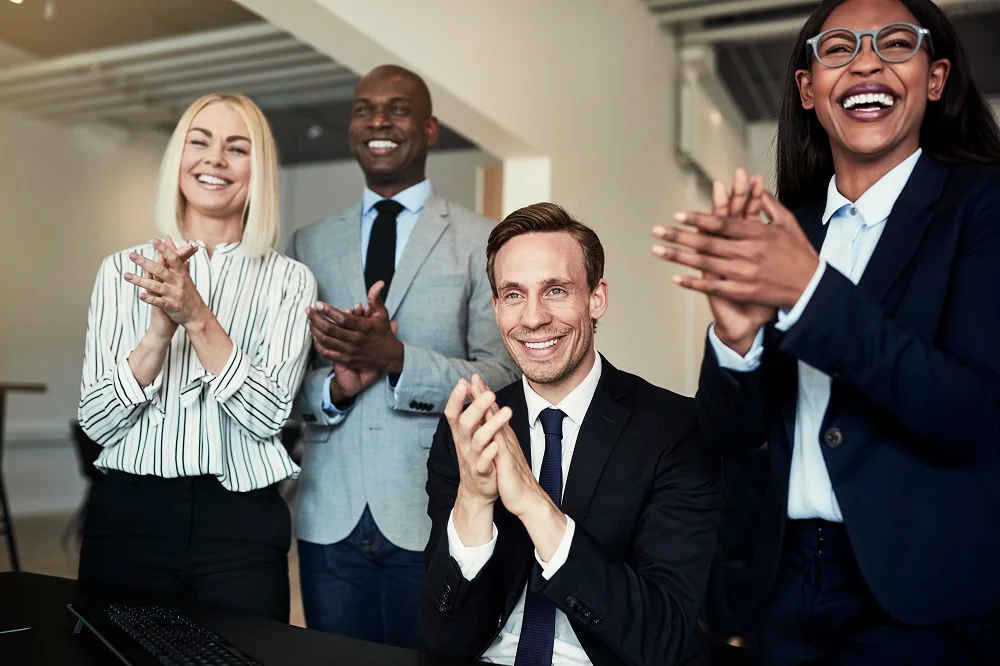 group of businesspeople smiling and clapping after 2026 01 05 00 50 56 utc