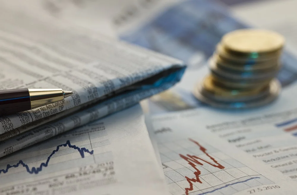financial newspaper with pen and stack of coins 2026 01 07 07 15 35 utc