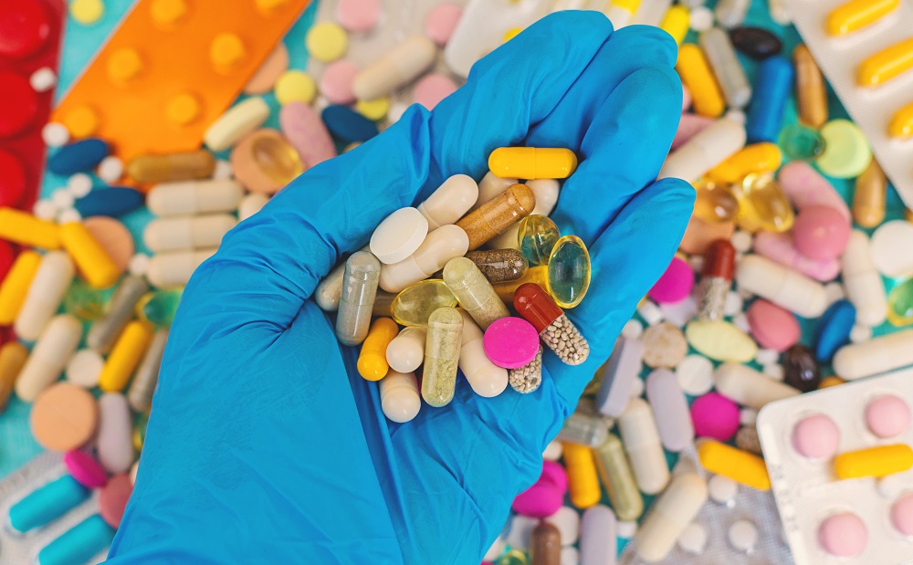 hand in blue glove holds various pills 2026 03 25 04 45 27 utc