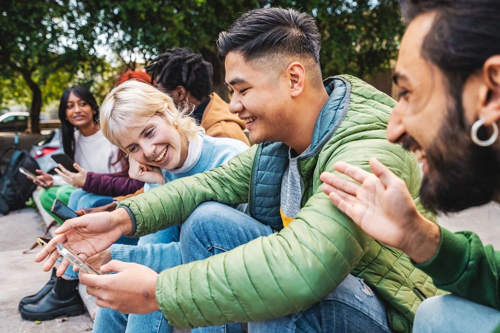 happy young people sitting together outdoors 2026 01 08 07 10 54 utc