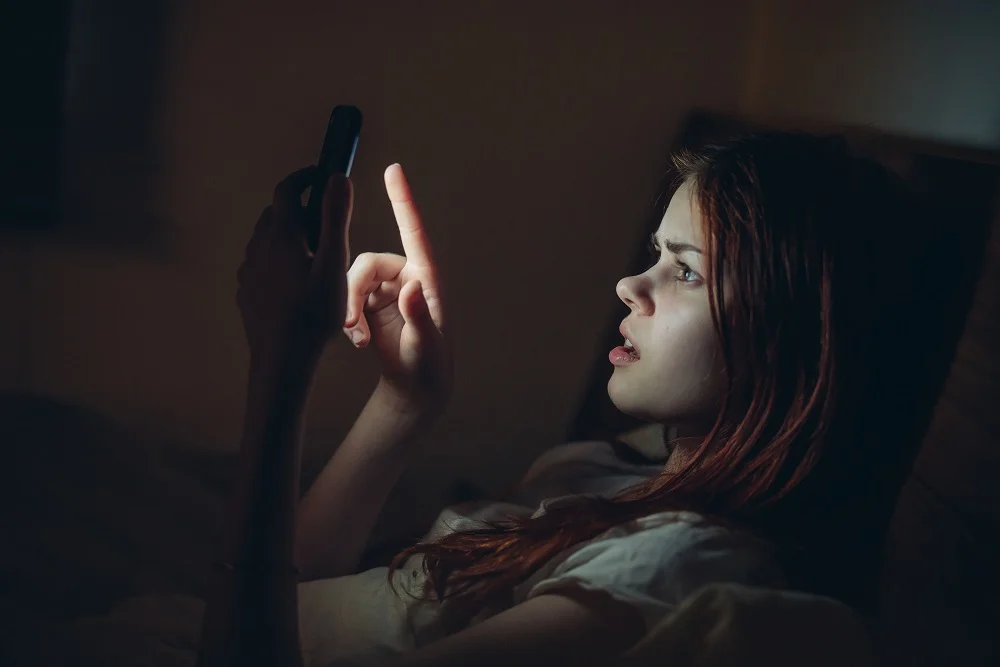 woman using phone in dimly lit bedroom 2026 03 24 05 59 15 utc
